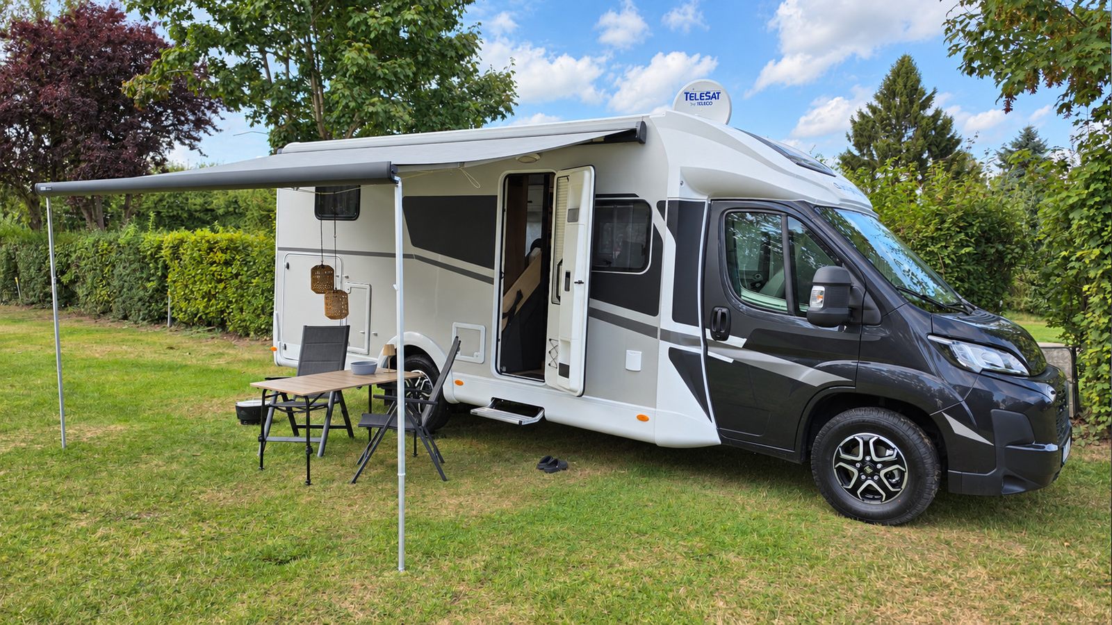 Schwarz-silbernes Pandamobil Sunlight T67 von vorne auf der Wiese